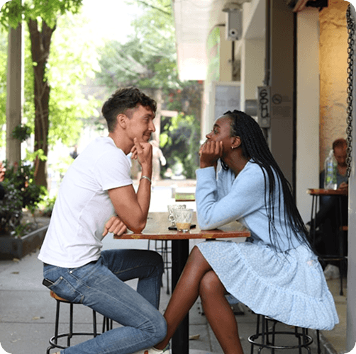 Two people talking at an outdoor cafe table